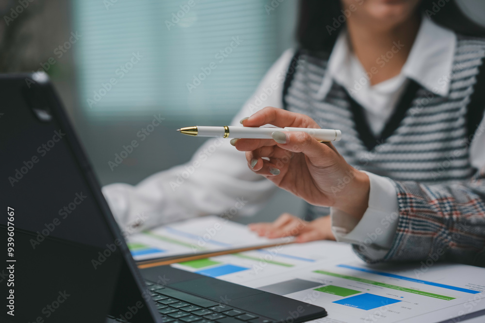 Poster two business colleagues are discussing over financial data displayed on a tablet, with one of them p