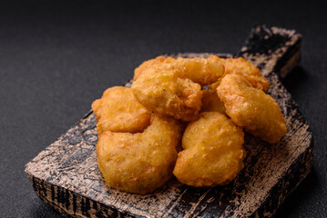 Delicious fresh crispy chicken nuggets on a dark concrete background