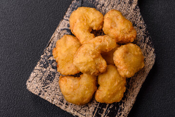 Delicious fresh crispy chicken nuggets on a dark concrete background