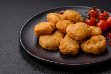 Delicious fresh crispy chicken nuggets on a dark concrete background