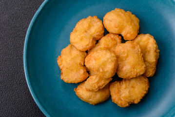 Delicious fresh crispy chicken nuggets on a dark concrete background