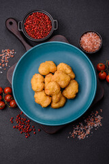 Delicious fresh crispy chicken nuggets on a dark concrete background