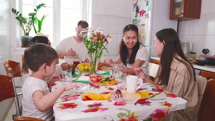 A family sits at the table early in the morning and enjoys breakfast together