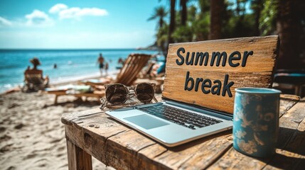 Wooden sign reading 'summer break' on beach table with laptop and sunglasses