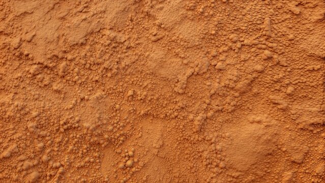 Textured surface in warm orange tones resembling clay or powder