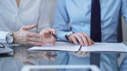 Diverse business people discussing contract papers before signing. Teamwork of lawyers are at work at the glass desk in office