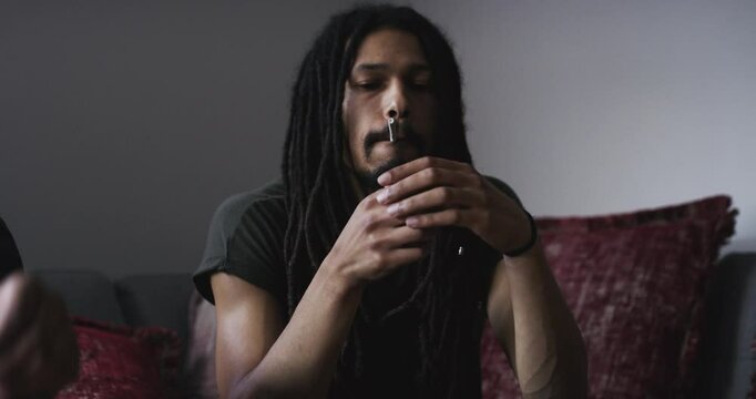 Cannabis, blunt or man lighting joint hemp, home marijuana or 420 CBD for addiction, drugs or stress relief wellness. Smoking pot, living room couch or Nigeria smoker with weed, THC or Indica product