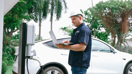 Qualified technician working on home EV charging station installation, making troubleshooting and...