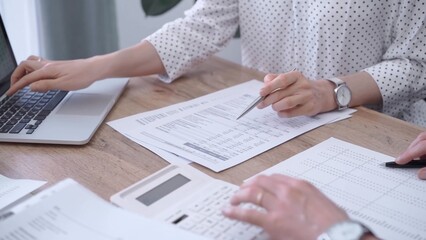 Professional female bookkeeper or auditor are working on business finances with a colleague, using calculator and laptop. Finance audit and taxes