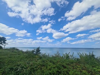 grüne Landschaft mit einem schönen, blauen Wolkenhimmel und Blick auf die Ostsee in Wilhelmshagen, Mecklenburg - Vorpommern
