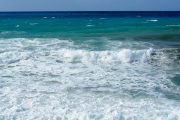 View of Mediterranean sea waves with white foam in Greece