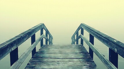   A wooden dock with a bench amidst a misty waterway