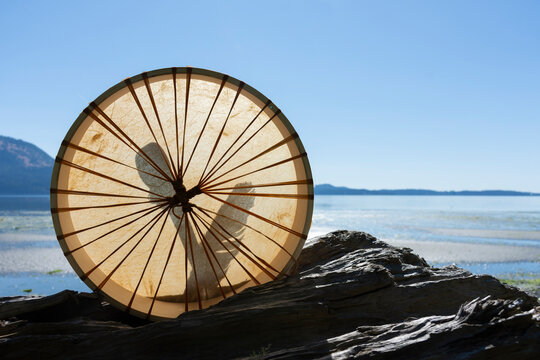 A silhouette image of a handmade leather meditation drum with ocean background. 