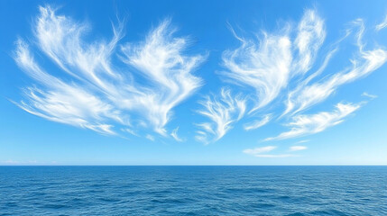Obraz premium Beautiful wispy clouds above a tranquil ocean during a clear day