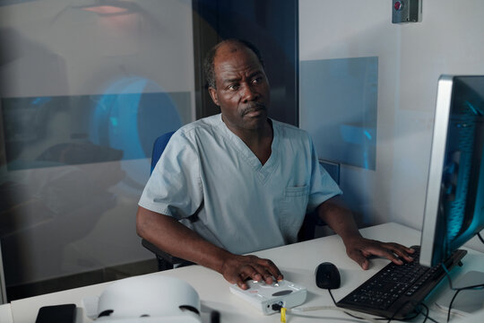 Portrait of man handling device in medical research lab, focusing on work at computer monitor