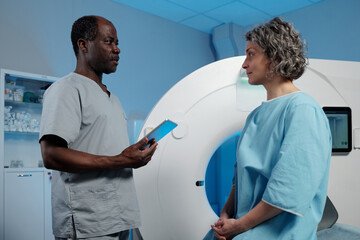Medical professionals discussing MRI procedure with patient in modern medical facility ensuring patient comfort 