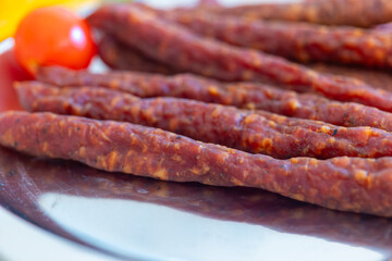 plate of meat with a tomato on top