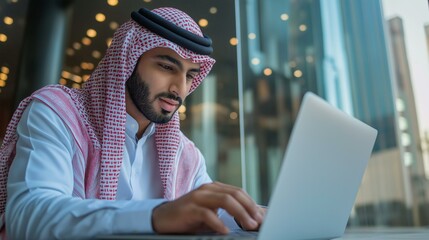 Saudi arab man working on a laptop 