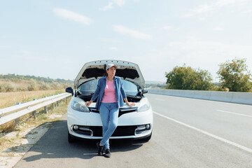 Frustrated Young Woman Stands Beside Broken Car on Highway