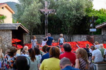 Pilgrims praying and lighting candles at the Cross near the Saint James Church in Medjugorje.
