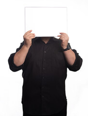 Adult man, an adult man in black clothing holding a blank sign in front of a white background, selective focus.