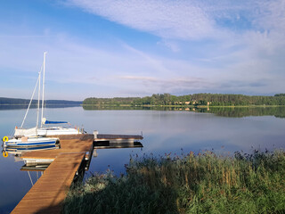 Fototapeta premium A sailboat moored at the shore of the lake Wdzydze.