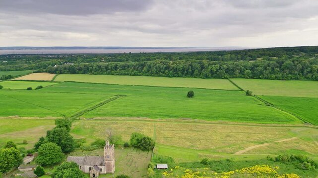 Aerial view of a medieval church and green fields