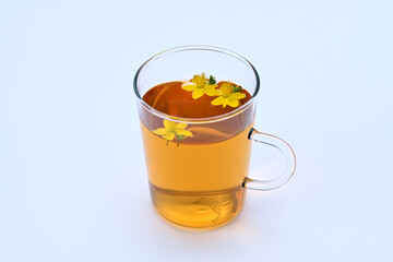 herbal tea with St. John's wort in a transparent cup on a white background