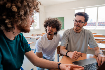 A group of happy diverse college students studying together in the classroom.