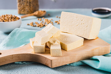 Cubes of fresh organic tofu cheese with rosemary on a board close-up
