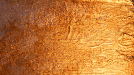 Shimmering metallic surface with a golden textured background