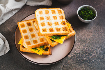Morning waffle toast with melted cheese on a plate on the table