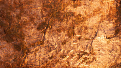 Abstract background with warm color tones formed by rough and uneven textured metal surface