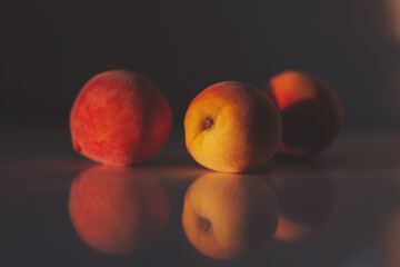 three peaches on a peach background with a beautiful shadow. juicy ripe peaches in sunlight and shadow. 
