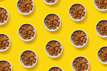 Pattern made with bowls of oatmeal on yellow background. Creative breakfast concept