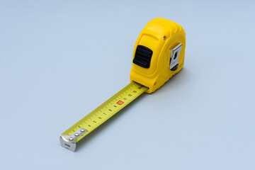 Yellow measuring tape isolated on the blue background.