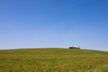 ferme ancienne en pierres isolée au sommet d'une colline, scène minimaliste