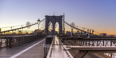 Naklejka premium Brooklyn Bridge over East River viewed from New York City Lower Manhattan waterfront at sunrise
