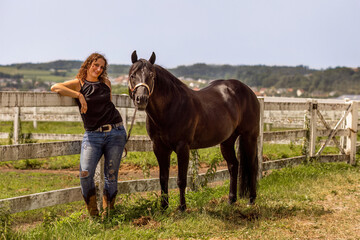 Equestrian lifestyle: A woman and her quarter horse stallion interacting together in summer outdoors