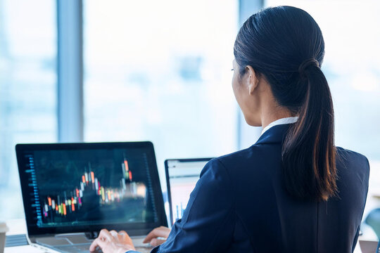 パソコンを操作するビジンネスウーマンの後ろ姿