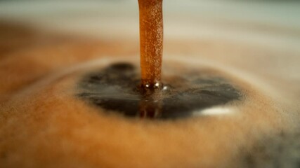 Super Slow Motion Shot of Perfect Drop Falling into Fresh Creamy Coffee at 1000fps.