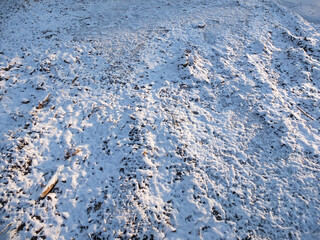 Dusting of snow and ice on grass and ground in winter