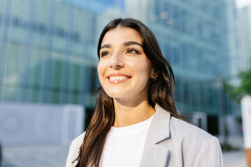 Young empowered businesswoman standing over company building office. Entrepreneur vision and...
