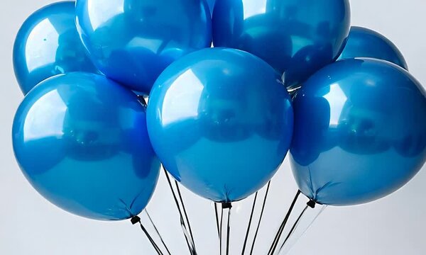 Bunch of blue balloons tied together with ribbons, isolated on white background