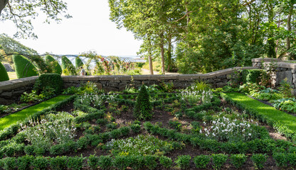 Garden outside castle with plants and ocean at background