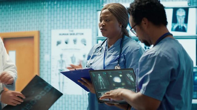 Medical professionals review x ray results and discuss patient care strategies during a meeting. Team of licensed healthcare experts working to provide accurate diagnosis in a clinic. Camera A.