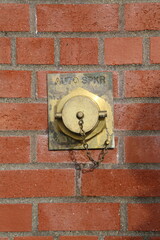 Standpipe installed against a red brick wall.