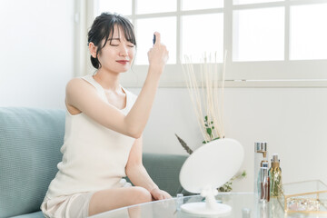 スプレーの化粧水でスキンケアするアジア人女性
