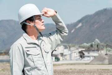 ヘルメットを被った作業着姿のアジア人男性作業員
