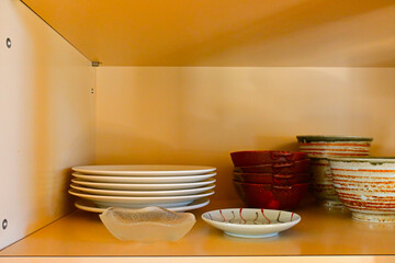 Many dishes are stored on shelves, white shelves, stacked, Japanese dishware.